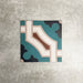 Single London Streets Leicester Square 20x20cm Victorian Moroccan style porcelain tile displayed in a product setting, featuring a geometric pattern in teal, cream and terracotta tones inspired by traditional decorative Victorian style floor tiles.