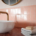 Liberty Blush Pink 7.5cm x 15cm rustic effect gloss wall tiles, featuring a softly rippled surface and blush pink finish in a vertical layout, paired with a terrazzo effect worktop and warm brass details.