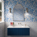 Bathroom featuring Liberty White 7.5x15cm rustic effect gloss wall tiles laid in a herringbone pattern, paired with blue botanical wallpaper, a navy fluted vanity unit, chrome wall lights and an arched mirror for a fresh, classic look.