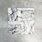 Arrangement of Fayrouz Lilac 5x20cm natural marble tiles with a honed finish, displayed in a mixed layout pattern to showcase variation, featuring a soft white base with flowing lilac and grey veining, highlighting the natural movement and individuality of each tile.