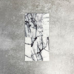Arrangement of Fayrouz Lilac 5x20cm natural marble tiles with a honed finish, displayed in a vertical layout to highlight variation, featuring a soft white base with striking lilac and grey veining, showcasing the natural movement and unique character of each piece.