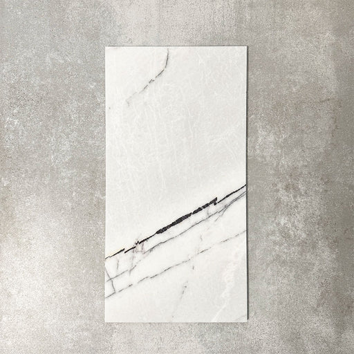 Fayrouz Lilac 30.5x61cm natural marble tiles with a honed finish, featuring a soft white base with subtle lilac undertones and fine grey veining, shown as a single tile sample against a neutral textured backdrop.