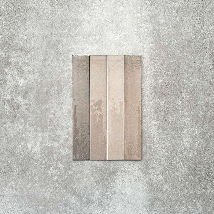 Close-up of Lisbon Grey 5cm x 30cm artisanal porcelain wall tiles arranged vertically, showcasing warm grey and taupe tones, subtle tonal variation and a handcrafted-effect surface finish.