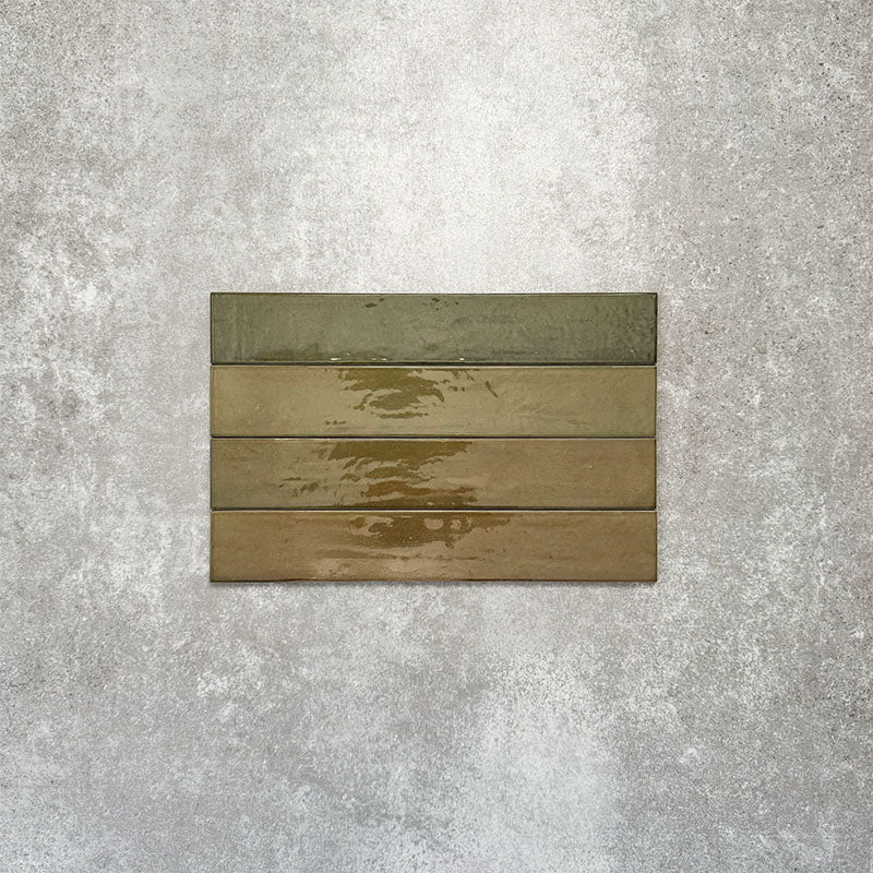 Close-up of Lisbon Olive Green 5cm x 30cm artisanal porcelain wall tiles arranged horizontally, showcasing earthy olive green tones, subtle tonal variation and a glossy handcrafted-effect surface finish.