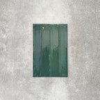 Close-up of Lisbon Verde Green 5cm x 30cm artisanal porcelain wall tiles arranged vertically, showcasing rich green tones, subtle tonal variation and a glossy handcrafted-effect surface finish.