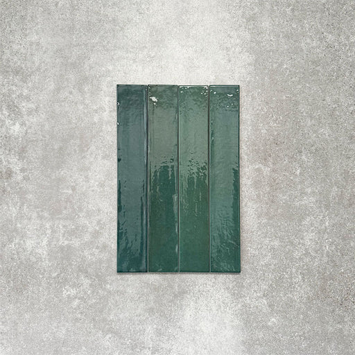 Close-up of Lisbon Verde Green 5cm x 30cm artisanal porcelain wall tiles arranged vertically, showcasing rich green tones, subtle tonal variation and a glossy handcrafted-effect surface finish.