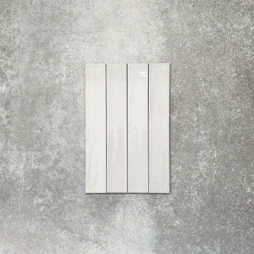 Close-up of Lisbon White 5cm x 30cm artisanal porcelain wall tiles arranged vertically, showcasing soft white tones, subtle tonal variation and a handcrafted-effect surface finish.