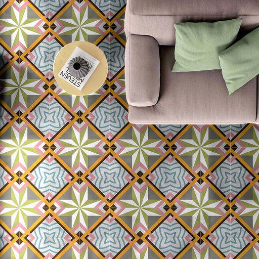 Living room interior featuring Cuba Star Moroccan-style porcelain floor tiles in a 20×20cm square format, displaying a bold geometric star pattern in soft green, blue, pink and mustard tones, styled with a neutral sofa and pastel cushions to create a bright, contemporary space with vintage character.
