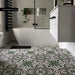 Bathroom interior featuring London Streets Bond Street 20 × 20cm Victorian Moroccan-style porcelain floor tiles, styled with an intricate green, grey, and black patterned design, paired with glossy white wall tiles, matte black fittings, and a freestanding bath for a bold, timeless look.