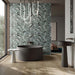 Luxury bathroom featuring Lucca Bali 3D Décor 60 × 120cm porcelain wall tiles, showcasing layered tropical leaf patterns in soft green tones, paired with contemporary black sanitaryware and warm wood finishes.