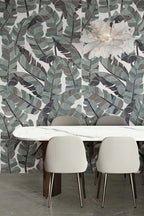 Dining area featuring Lucca Bali 3D Décor 60 × 120cm porcelain wall tiles, showcasing layered tropical leaf patterns in soft green and charcoal tones, paired with contemporary furniture and elegant modern interiors.