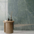 Interior featuring Lucca Ocean Green Lux 3D 60 × 120cm porcelain wall tiles, showcasing rich green marble-effect tones with delicate veining, paired with warm wood furniture and contemporary spa-inspired styling.