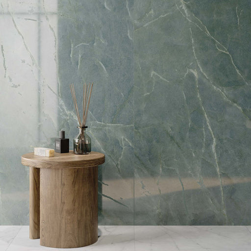 Interior featuring Lucca Ocean Green Lux 3D 60 × 120cm porcelain wall tiles, showcasing rich green marble-effect tones with delicate veining, paired with warm wood furniture and contemporary spa-inspired styling.