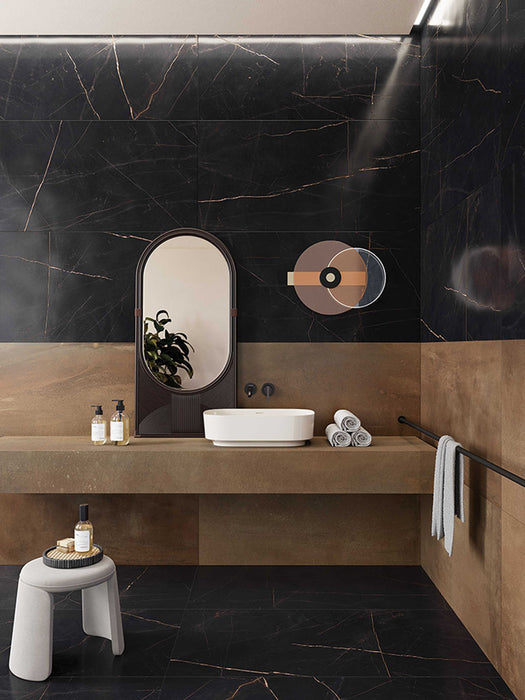 Contemporary bathroom interior featuring Lucca Precious Noir Lux 3D 60 × 120cm porcelain wall and floor tiles, combining deep black marble-effect surfaces with subtle gold veining, warm bronze tones, and minimalist fittings for a sophisticated luxury aesthetic.