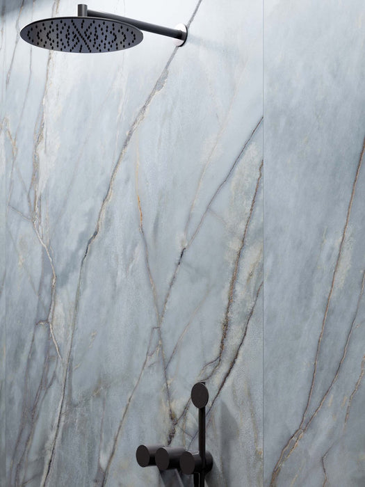 Walk-in shower featuring Lucca River Blue Lux 3D 60 × 120cm porcelain wall tiles, showcasing soft blue marble-effect tones with delicate veining, paired with matt black shower fittings and contemporary spa-inspired styling.