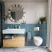 Bathroom featuring Lucca River Blue Matt 60cm x 120cm floor tiles, paired with blue wall tiles, white square tiles, a floating wooden vanity and a round statement mirror.