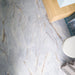 Lucca River Blue 60cm x 120cm matt tiles, showcasing soft blue-grey tones with flowing marble effect veining and warm golden detailing across a large-format bathroom floor.