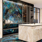 Luxury kitchen interior featuring Lumen Precious Stone Labradorite 60 × 120cm polished porcelain wall and floor tiles, showcasing dramatic blue, teal, and black gemstone-inspired tones with a high-gloss finish, paired with a marble-effect island and dark contemporary cabinetry.