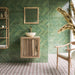 Contemporary bathroom featuring Madeira Vino 20x20cm Moroccan-style patterned floor tiles, with burgundy, pink and cream geometric floral motifs, paired with forest green herringbone wall tiles, natural wooden furniture, a cream basin and brass fittings.