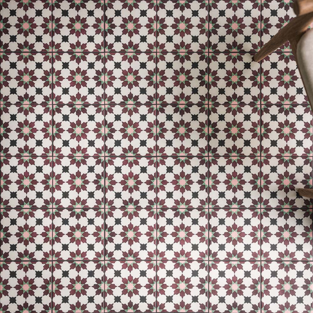 Close-up of Madeira Vino 20x20cm Moroccan-style patterned wall and floor tiles, featuring intricate burgundy, pink, mint green and black geometric star motifs against a cream background, arranged in a repeating decorative design.