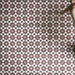 Close-up of Madeira Vino 20x20cm Moroccan-style patterned wall and floor tiles, featuring intricate burgundy, pink, mint green and black geometric star motifs against a cream background, arranged in a repeating decorative design.