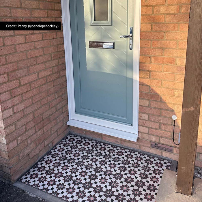 Entrance featuring Madeira Vino Moroccan style 20cm x 20cm floor tiles, showcasing an intricate burgundy, pink and white geometric pattern, creating a decorative statement against the warm brick exterior and sage green front door.