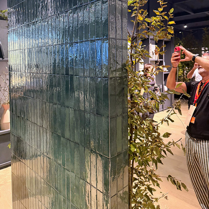 Close-up of Puzzle Forest Green Brick rectified wall and floor tiles in 5x20cm format, installed vertically on a feature wall, highlighting glossy surface texture and rich green tonal variation in a contemporary setting.