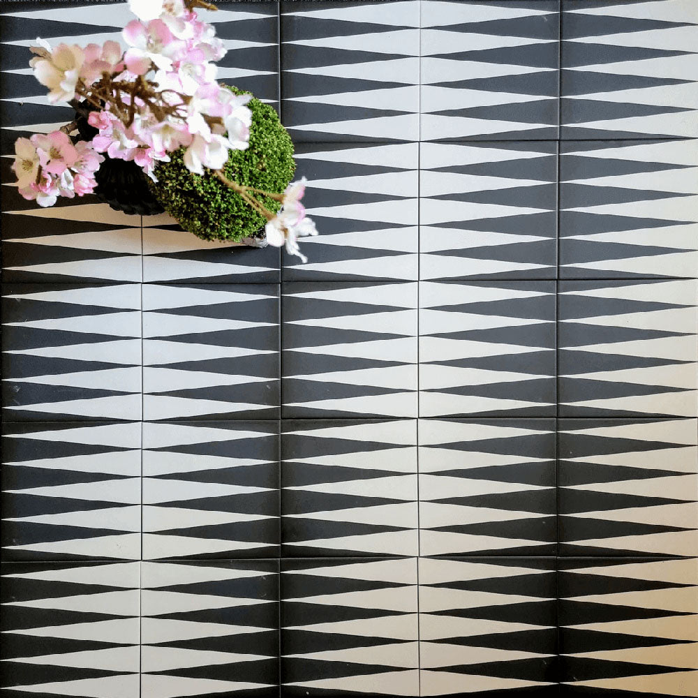 Almeria Backgammon Moroccan-style porcelain wall and floor tiles laid in a repeating black and white geometric pattern, 20x20cm, creating a bold and graphic statement.