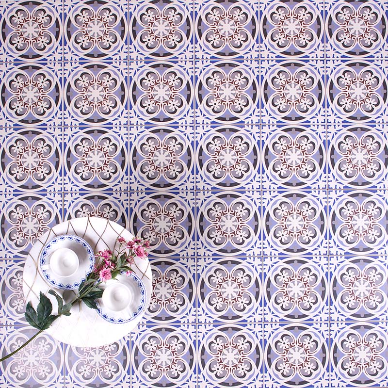 Patterned surface featuring Imperial Victorian Blue Mini Tiles, 15x15cm porcelain tiles with a classic Victorian-inspired design in soft blue, grey, and white tones, styled with decorative tableware and flowers.