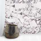 Interior setting featuring Fayrouz Viola 30.5x61cm natural marble tiles with a honed finish, installed in a staggered layout, showcasing a white base with rich burgundy veining, styled with soft textiles and natural textures for a relaxed, refined look.