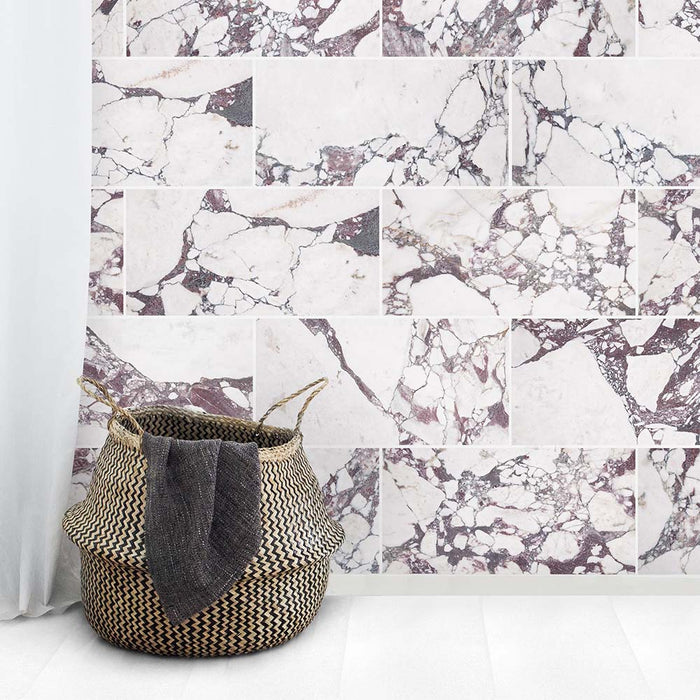 Interior setting featuring Fayrouz Viola 30.5x61cm natural marble tiles with a honed finish, installed in a staggered layout, showcasing a white base with rich burgundy veining, styled with soft textiles and natural textures for a relaxed, refined look.