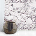 Interior setting featuring Fayrouz Viola 30.5x61cm natural marble tiles with a honed finish, installed in a staggered layout, showcasing a white base with rich burgundy veining, styled with soft textiles and natural textures for a relaxed, refined look.