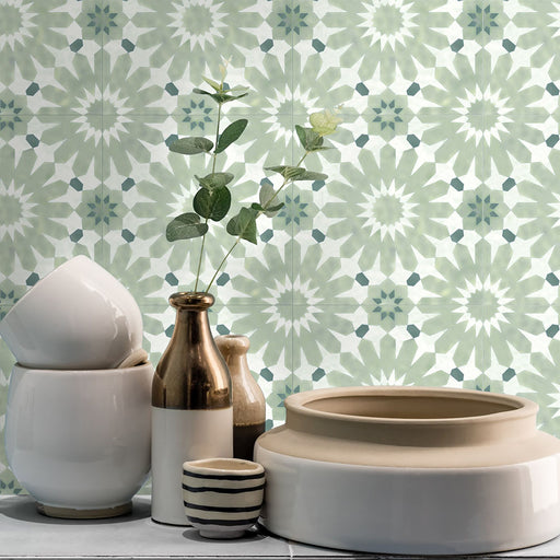 Bathroom vanity splashback featuring Fez Mini Jade Green 15x15cm Moroccan-style porcelain tiles, showcasing a soft green geometric star pattern, styled with ceramic accessories, neutral tones and delicate greenery for a calm, decorative finish.