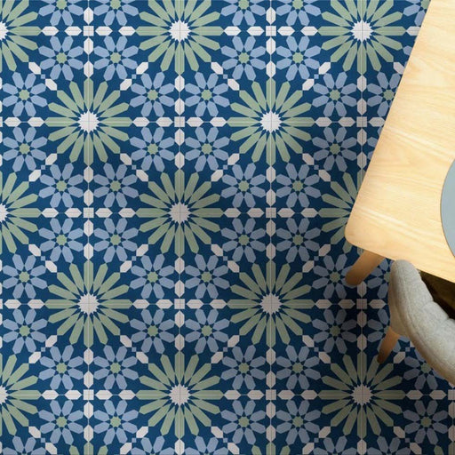 Dining area floor featuring Fez Springs 20x20cm Moroccan-style porcelain tiles, showcasing a repeating geometric star pattern in layered blue and green tones, styled with light wood furniture and soft grey seating for a fresh, contemporary look.
