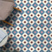 Interior floor featuring Cuba Guazzatto Moroccan-style porcelain tiles in a 20×20cm square format, arranged in a repeating geometric diamond pattern in soft blue, white, pink and burgundy tones, styled with contemporary furniture to highlight the tile’s bold yet balanced design.