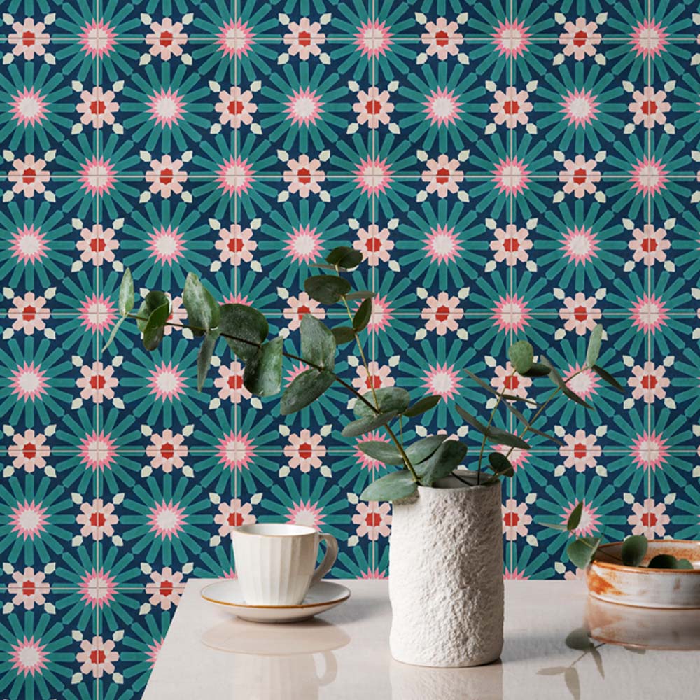 Kitchen splashback featuring Fez Mini Festival 15x15cm Moroccan-style porcelain tiles, showcasing a bold multicolour geometric pattern in teal, pink and warm neutral tones, styled with ceramic accessories and leafy greenery for a vibrant, characterful finish.
