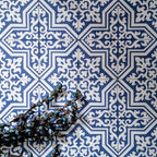 Overhead view of London Streets Thornton Place 20x20cm Victorian Moroccan style porcelain tiles arranged in a repeating blue and white patterned layout, styled with decorative foliage to highlight the intricate traditional Victorian-inspired floor design.