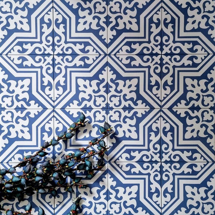 Overhead view of London Streets Thornton Place 20x20cm Victorian Moroccan style porcelain tiles arranged in a repeating blue and white patterned layout, styled with decorative foliage to highlight the intricate traditional Victorian-inspired floor design.