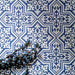 Overhead view of London Streets Thornton Place 20x20cm Victorian Moroccan style porcelain tiles arranged in a repeating blue and white patterned layout, styled with decorative foliage to highlight the intricate traditional Victorian-inspired floor design.
