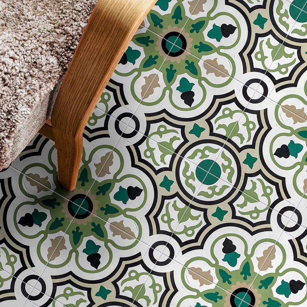 Interior floor setting featuring London Streets Bond Street 20x20cm Victorian Moroccan style floor tiles, styled beside a wooden chair with textured upholstery, showcasing a decorative geometric pattern in green, black and cream tones.