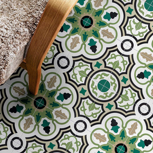 Interior floor setting featuring London Streets Bond Street 20x20cm Victorian Moroccan style floor tiles, styled beside a wooden chair with textured upholstery, showcasing a decorative geometric pattern in green, black and cream tones.