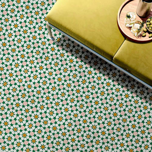 Interior floor featuring Cuba Tanane Moroccan-style porcelain tiles in a 20×20cm square format, showcasing a repeating star and geometric pattern in green, white, soft pink and warm yellow tones, styled with a mustard upholstered bench and tray to highlight the intricate design and vibrant colour palette.
