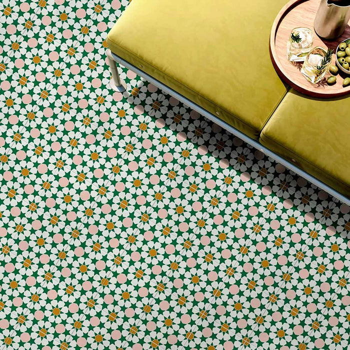 Interior floor featuring Cuba Tanane Moroccan-style porcelain tiles in a 20×20cm square format, showcasing a repeating star and geometric pattern in green, white, soft pink and warm yellow tones, styled with a mustard upholstered bench and tray to highlight the intricate design and vibrant colour palette.