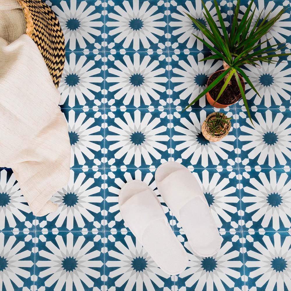 Interior floor featuring Souk Blue B 20×20cm Moroccan-style porcelain tiles with a blue and white geometric pattern, styled with soft furnishings and plants.