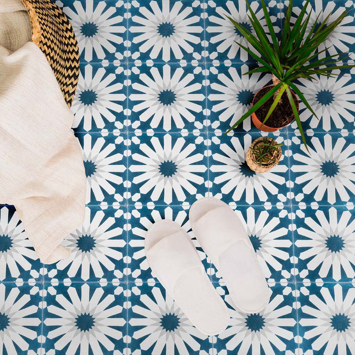 Interior floor featuring Souk Blue B 20×20cm Moroccan-style porcelain tiles with a blue and white geometric pattern, styled with soft furnishings and plants.
