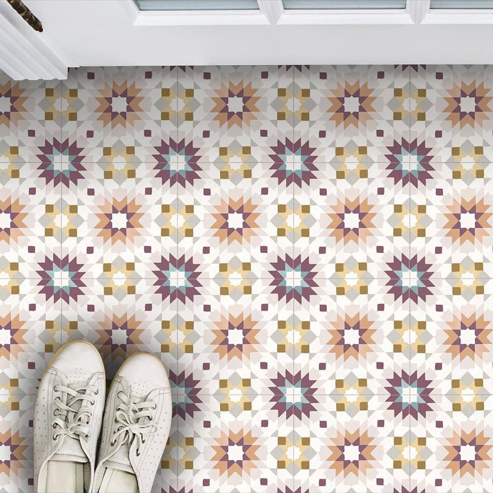 Interior floor featuring Cuba Manzanillo Moroccan-style porcelain tiles in a 20×20cm square format, arranged in a repeating geometric star pattern in soft cream, mustard, teal and burgundy tones, shown from above to highlight the tile’s intricate symmetry and decorative encaustic-style design.
