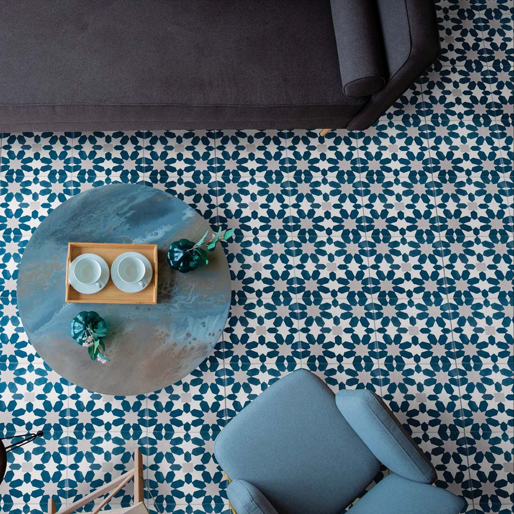 Living room floor featuring Souk Blue C 20×20cm Moroccan-style porcelain tiles with a blue and white geometric pattern.