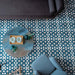 Living room floor featuring Souk Blue C 20×20cm Moroccan-style porcelain tiles with a blue and white geometric pattern.