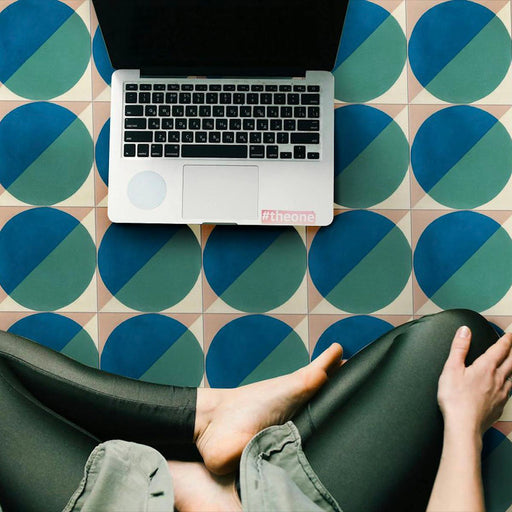 Modern interior featuring Abstract Ocean Patterned Tiles in a 20x20cm format, laid as a bold geometric floor design. The repeating circular pattern in deep blue and teal tones creates a fresh, contemporary look, styled with a laptop and relaxed seating to highlight the tiles in a creative home workspace setting.