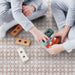 Children playing with wooden toys on Berber Mequinez Rose 15×15cm Moroccan-style porcelain floor tiles, featuring a soft pink geometric pattern in a family living space.